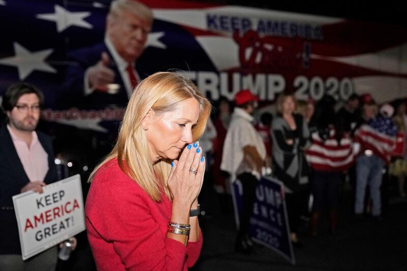 Lori Gibson, of Atlanta, listens to a speech by President Donald Trump prior to a press conference with Donald Trump Jr., at Georgia Republican Party Headquarters. AP Photo