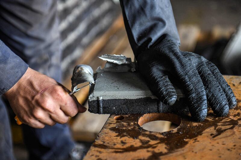 A TileGreen worker prepares moulds of plastic