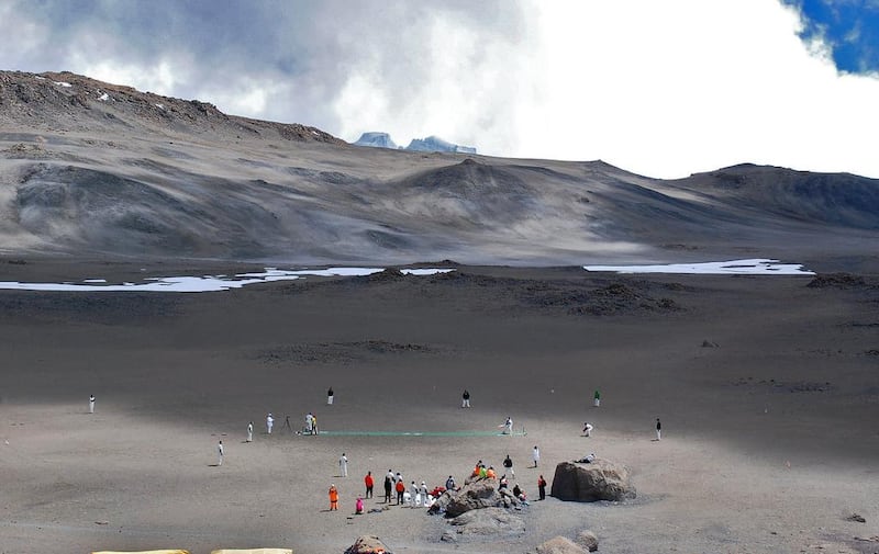 Cricketers play on September 26, 2014 on the ice-covered crater of the Kilimanjaro mountain, Tanzania . The game is an attempt to play the world's highest game of cricket, breaking the previous record set in 2009 on Mount Everest.  AFP PHOTO/PETER MARTELL

