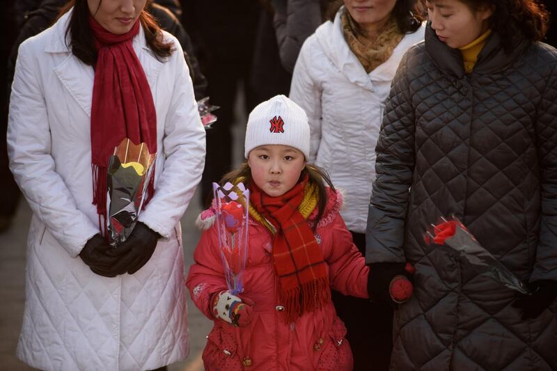 A girl holds flowers as she prepares to pay her respects. AFP