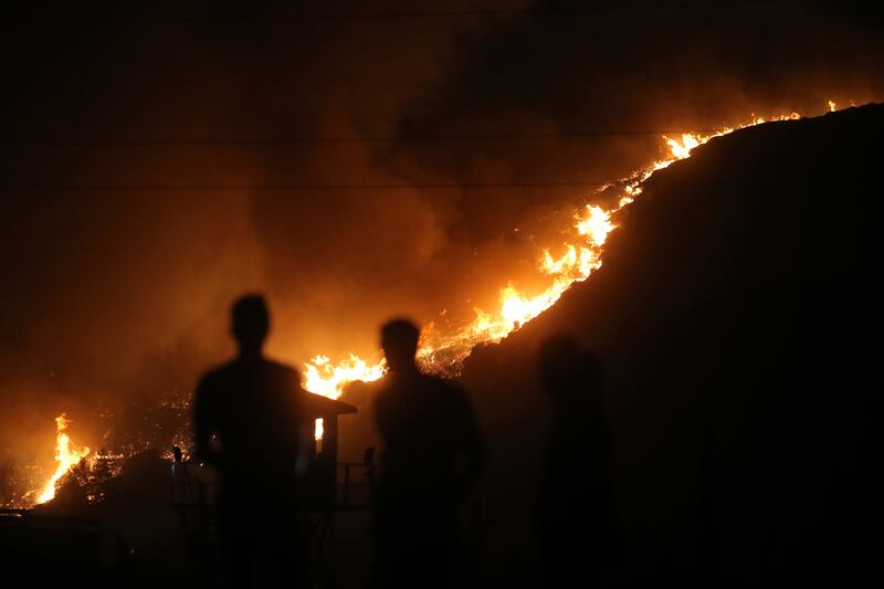 People watch as a wildfire approaches in Mugla, Turkey, last year. AP