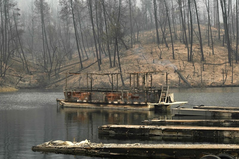 A burnt out boat sits at a marina on Whiskeytown Lake after damage from the Carr fire near Redding, California.  AFP PHOTO / Mark RALSTON
