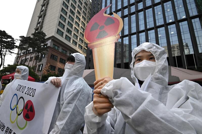 Anti-nuclear activists wearing white protective clothing stage a protest against the Tokyo 2020 Olympic Games. AFP