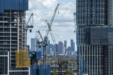 Canary Wharf financial district is seen in the distance as construction work continues on Damac's Nine Elms development on the South Bank. Covid-19 has affected sales of the project, which have stalled at a sold rate of almost 60 per cent since November last year. AFP