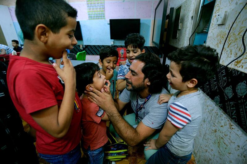 Hisham al-Dahabi, a social worker and philanthropist, examines the teeth of students at the orphanage he runs in the heart of Baghdad, Iraq. AP Photo