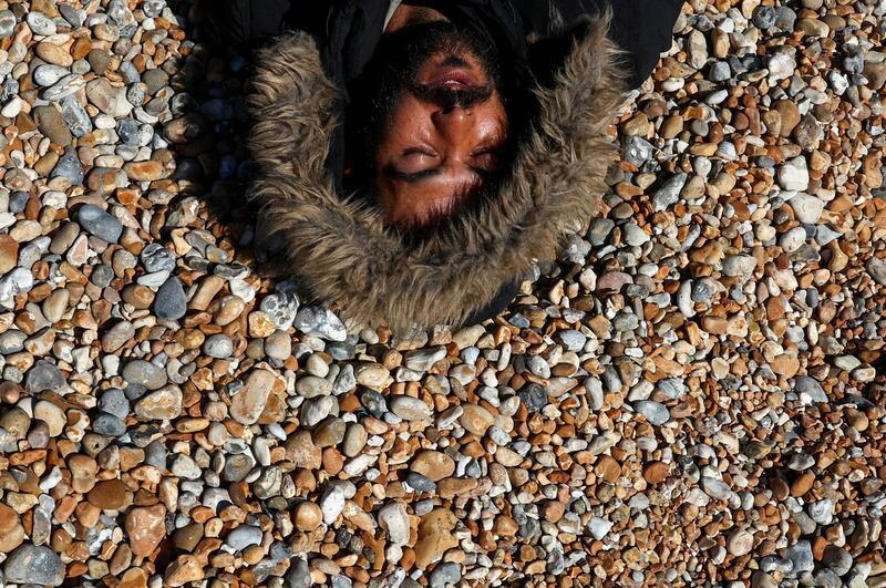 A migrant rests on the beach after arriving in Dungeness. Reuters