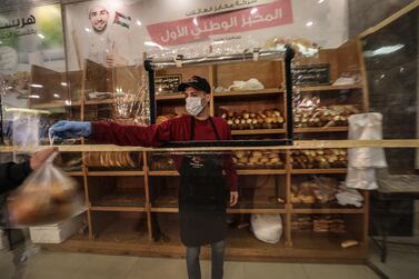 A bakery worker wears a face mask during his work at the family bakery as a precaution against the spread of the Covid-19 coronavirus, in Gaza City, March 17, 2020. EPA