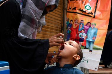 A health worker administers polio vaccine drops to a child during a polio vaccination door-to-door campaign in Lahore. / AFP 