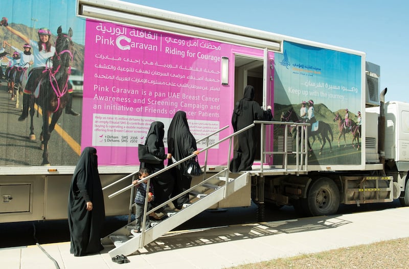 Women enter the UAE's Pink Caravan initiative mobile breast cancer screening unit.