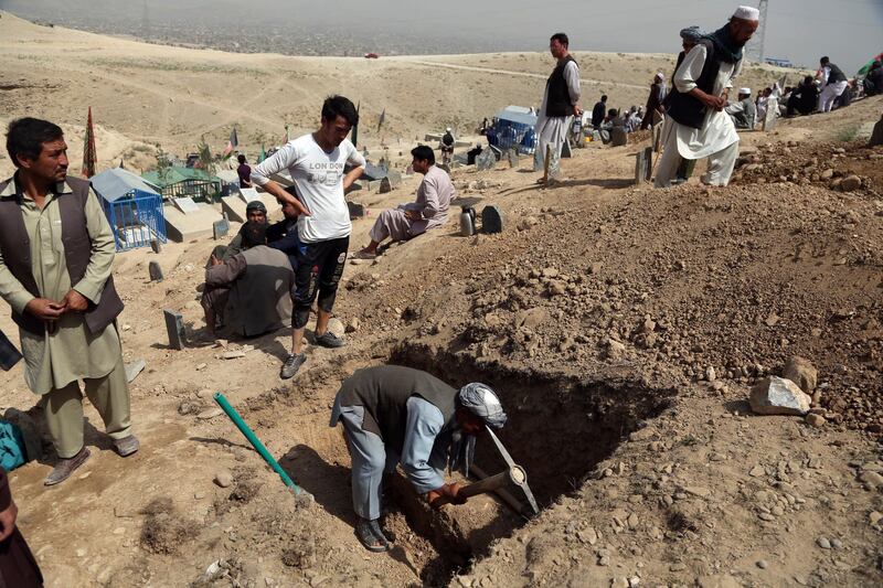 Afghan men prepare the graves for the victims of the bombing that targeted a training class in a private building in the Shiite neighborhood of Dasht-i Barcha. AP