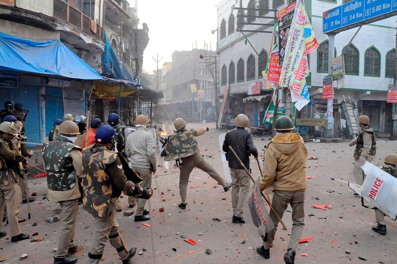 A Policeman throws stones towards protesters during demonstrations against India's new citizenship law in Kanpur.  AFP