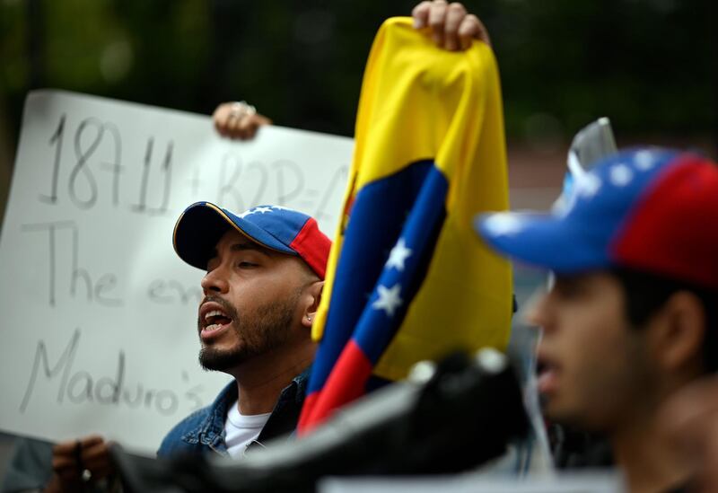 Supporters of the Venezuelan opposition hold banners at they protest on September 26, 2019 at the United Nations Headquarters in New York City. / AFP / Johannes EISELE
