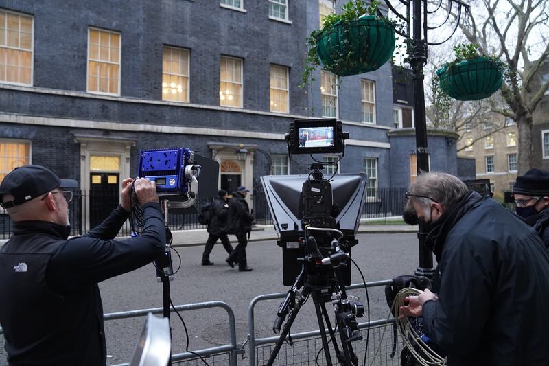 Armed police officers walk past the gathered media outside No 10 Downing Street on Tuesday morning. PA