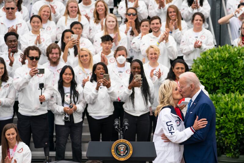 President Joe Biden kisses first lady Jill Biden, creating a photo op for the athletes on hand. AP