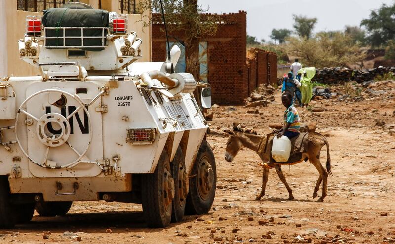 A Sudanese boy rides a donkey past a UN-African Union mission in Darfur (UNAMID) armoured vehicle in the war-torn town of Golo in the thickly forested mountainous area of Jebel Marra in central Darfur on June 19, 2017. The town was a former rebel bastion which was recently captured by Sudanese government forces. - The United States' top envoy in Sudan visited Golo on June 19, 2017 on the second day of his four-day trip to Darfur to assess security in the war-torn region as the UN prepares to downsize its 17,000-strong peacekeeping force. 
His visit also comes just weeks before President Donald Trump's administration decides whether to permanently lift a two-decades old US trade embargo on Sudan. (Photo by ASHRAF SHAZLY / AFP)