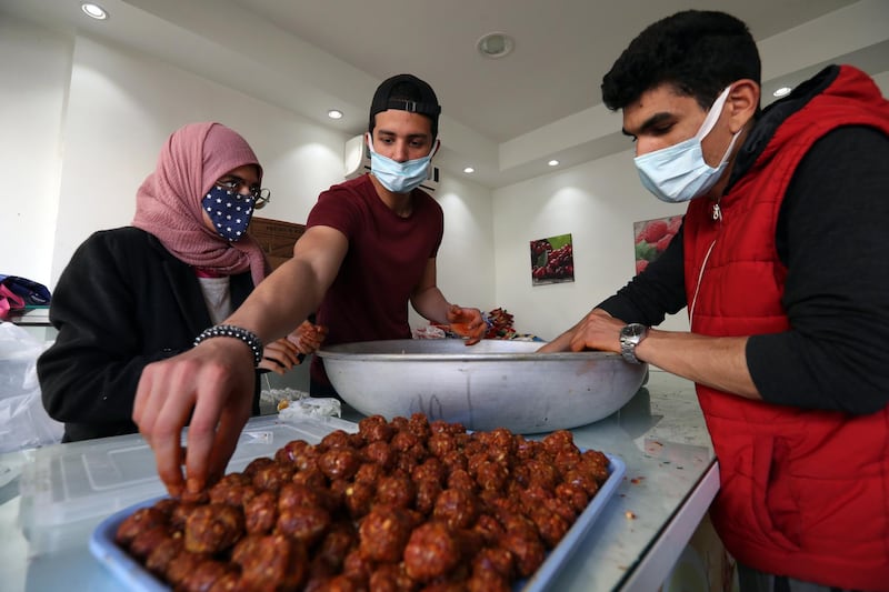 Young Tunisian volunteers prepare meals for people in need, in Ariana, in the capital Tunis. EPA