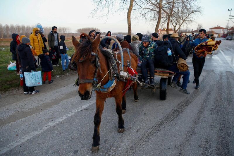 Migrants travel on a horse carriage near the Turkey's Pazarkule border crossing with Greece's Kastanies, near Edirne, Turkey. REUTERS