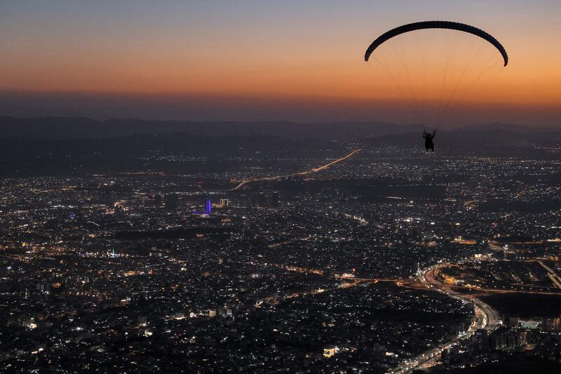 Members of the Sulaymaniyah paragliding team launch at sunset from Mount Azmar to glide over the city of Sulaymaniyah in north-eastern Iraq's autonomous Kurdistan region.