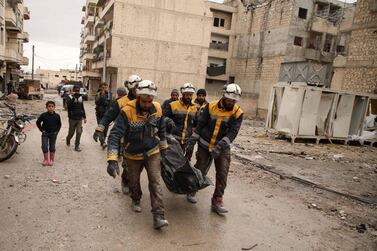 Syrian White Helmets carry a body recovered from the rubble of a building that was bombed in the town of Ariha in Idlib province. AFP 