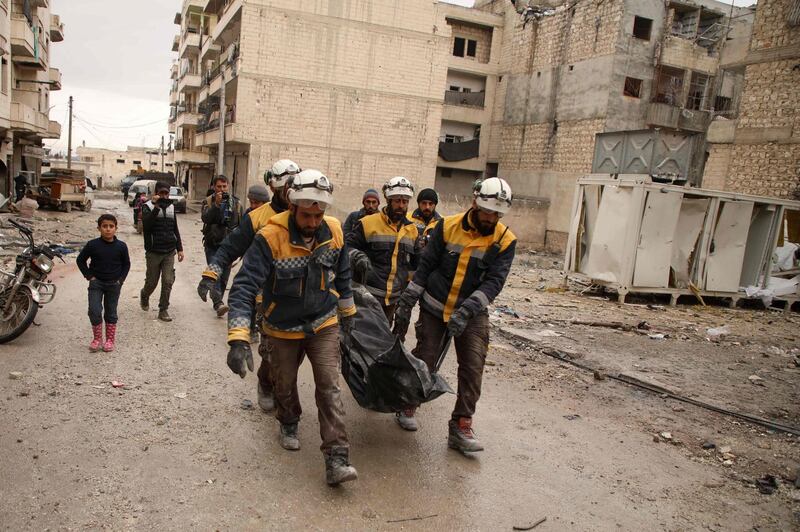 Members of the Syrian Civil Defence, also known as the White Helmets, carry the body of a woman recovered from the rubble of a building at the site of a reported airstrike on the rebel-held town of Ariha in the northern countryside of Syria's Idlib province early on January 30, 2020. Air strikes by government ally Russia hit near a bakery and a medical clinic in Syria's rebel-held Idlib region early on Thursday, killing 10 civilians, the Syrian Observatory for Human Rights said. At least five women were among the dead in the town of Ariha in Idlib province, where Russian-backed government forces are conducting an offensive against the country's last major rebel bastion. / AFP / AAREF WATAD
