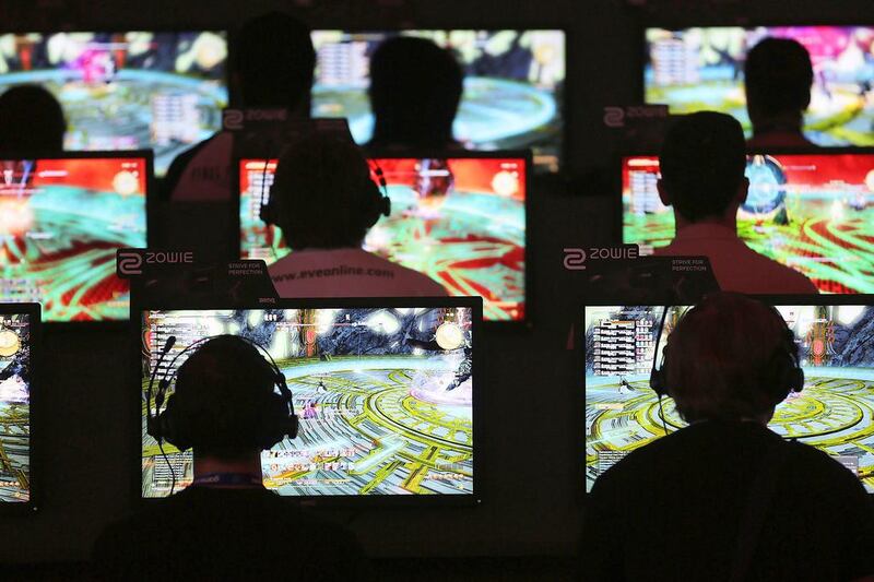 Trade visitors play computer games at Gamescom. Oliver Berg / EPA