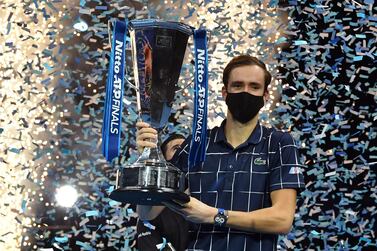 Russia's Daniil Medvedev wearing a protective face covering to combat the spread of the coronavirus, poses with the winner's trophy after his 4-6, 7-6, 6-4 win over Austria's Dominic Thiem in their men's singles final match on day eight of the ATP World Tour Finals tennis tournament at the O2 Arena in London on November 22, 2020. Daniil Medvedev came from a set down to beat Dominic Thiem 4-6, 7-6 (7/2), 6-4 and win the ATP Finals title in London on Sunday for the biggest tournament victory of his career. / AFP / Glyn KIRK
