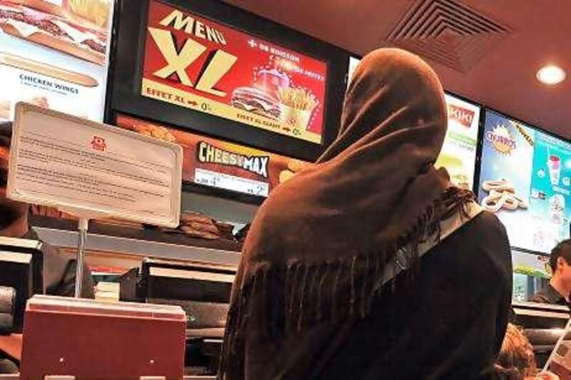 TO GO WITH AFP STORY : " Halal : aprËs la polÈmique, le Quick de Roubaix s'est bien dÈveloppÈ ". A veiled woman queues to be served in a Halal Quick fast-food restaurant in the northern French city of Roubaix on August 30, 2010. The fast-food brand said on August 31, 2010 it would extend the number of halal only restaurants in its chain in France, after a controversial pilot project in February proved a success. Some politicians reacted angrily to Quick's announcement earlier this year of its first halal-only branches, saying the chain had deprived non-Muslims of a right to standard burgers and promoted social divisions. But the French chain said it would switch 14 more of its French branches to serve only halal meat, certified as slaughtered in accordance with Islamic practices, bringing the total in France to 22 of its restaurants.     AFP PHOTO / PHILIPPE HUGUEN