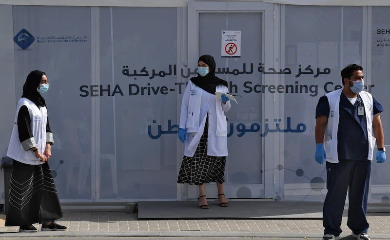 Medical volunteers wait outside a drive-through COVID-19 coronavirus testing centre in al-Khawaneej district of the gulf emirate of Dubai on April 9, 2020.  / AFP / KARIM SAHIB
