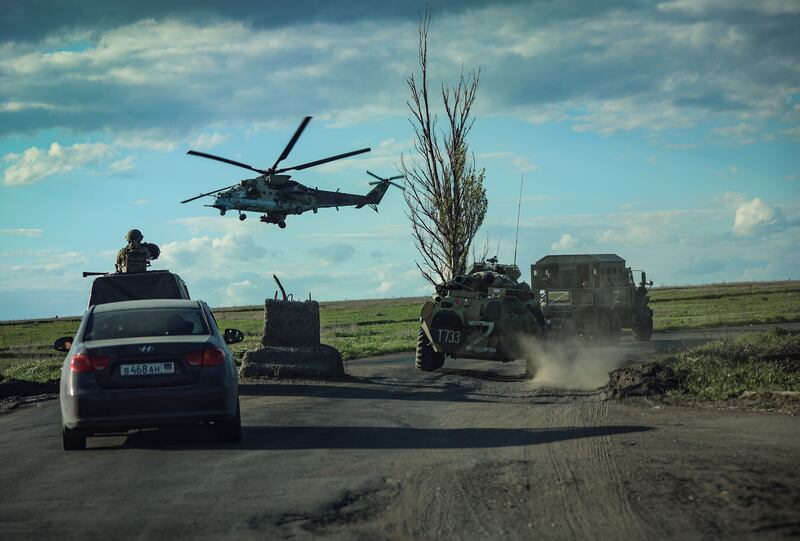 Russian militrary vehicles follow buses (not in picture) carrying Ukrainian troops being evacuated from the besieged Azovstal steel plant in Mariupol.   EPA