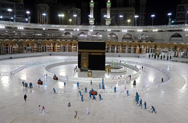 TOPSHOT - A picture taken on April 24, 2020, shows sanitation workers disinfection the area arround the Kaaba in Mecca's Grand Mosque, on the first day of the Islamic holy month of Ramadan, amid unprecedented bans on family gatherings and mass prayers due to the coronavirus (COVID-19) pandemic.  / AFP / STR
