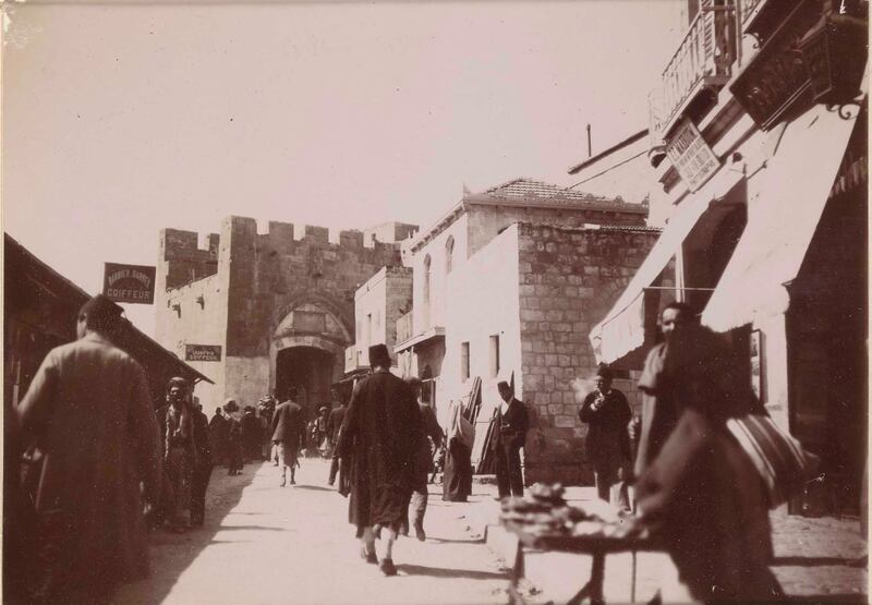 A street scene beside Jaffa Gate including a photography studio and barbers in Jerusalem, Palestine, 1898