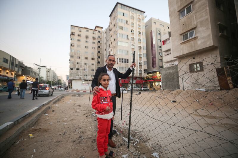 Riad Ishkontana, 43, and daughter Suzy, eight, stand on the trail of his destroyed house during the recent Israeli war on the Gaza Strip, where his family members were killed during an Israeli bombing of a residential complex. Majd Mohamad for The National