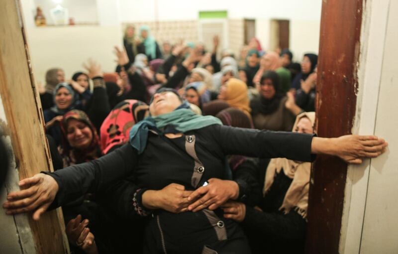 A Palestinian relative of Hamdan Abu Amsha, who was killed a day earlier by Israeli forces when clashes erupted as tens of thousands as Gazans marched near the Israeli border with the enclave to mark Land Day, cry during his funeral in Beit Hanun in the northern of Gaza Strip. Mahmud Hams / AFP