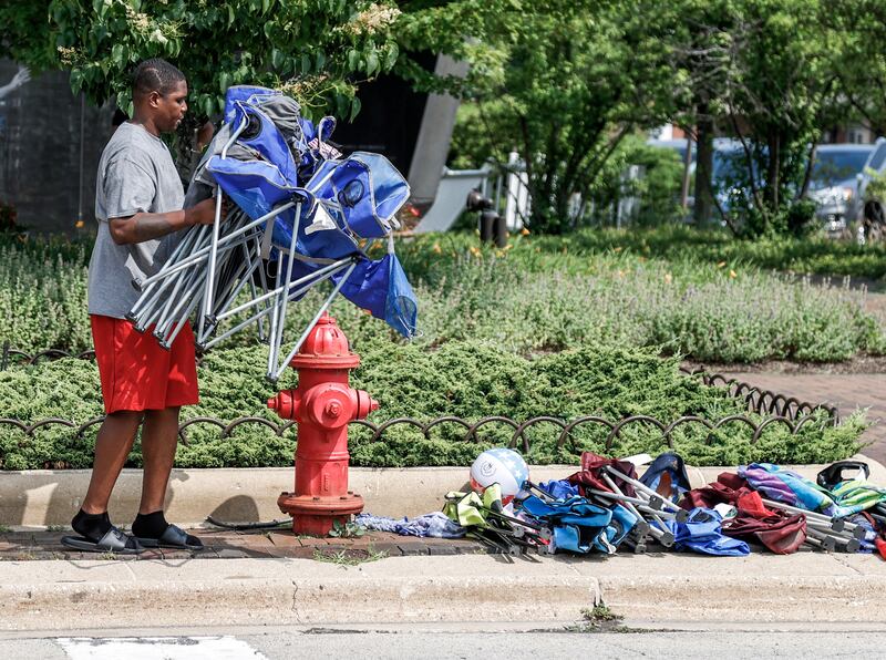 A man collects chairs that were abandoned by people fleeing the scene. EPA