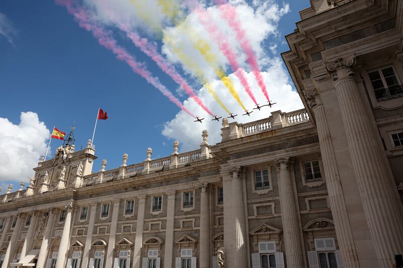 Eagle Patrol, the acrobatic unit of Spain's air force, leave a trail of smoke in the colours of the national flag as they fly over the Royal Palace Weapons Courtyard in Madrid on the 10th anniversary of King Felipe VI's coronation. EPA 