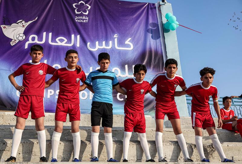 Children wearing Qatari strips pose for a photo during the opening ceremony of the Camps World Cup in Idlib.