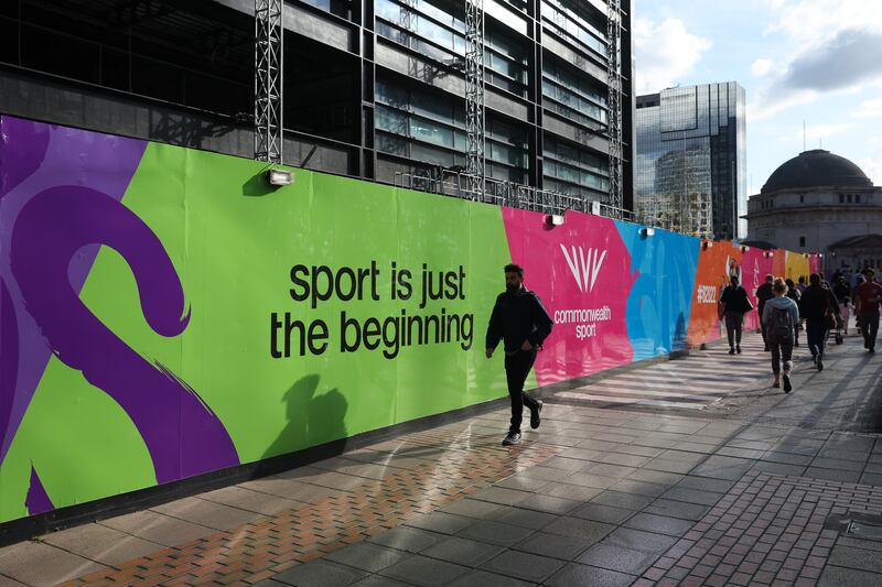 Pedestrians walk past Commonwealth Games branding in the city centre. Getty Images