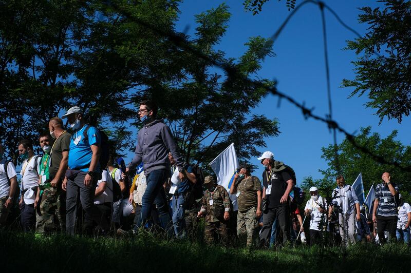 Bosnians, some of them survivors of the 1995 Srebrenica massacre, walk through a mountain area near Crni Vrh, Bosnia, July 8, 2020, during a Peace March recreating the path take 25 years ago by people trying to escape the advancing Serb forces. AP