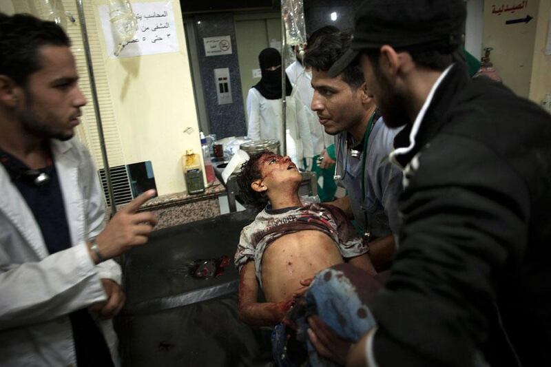 Syrian medics hold a child who died from government forces shelling at the Dar al-Shifa hospital in Aleppo, Syria.