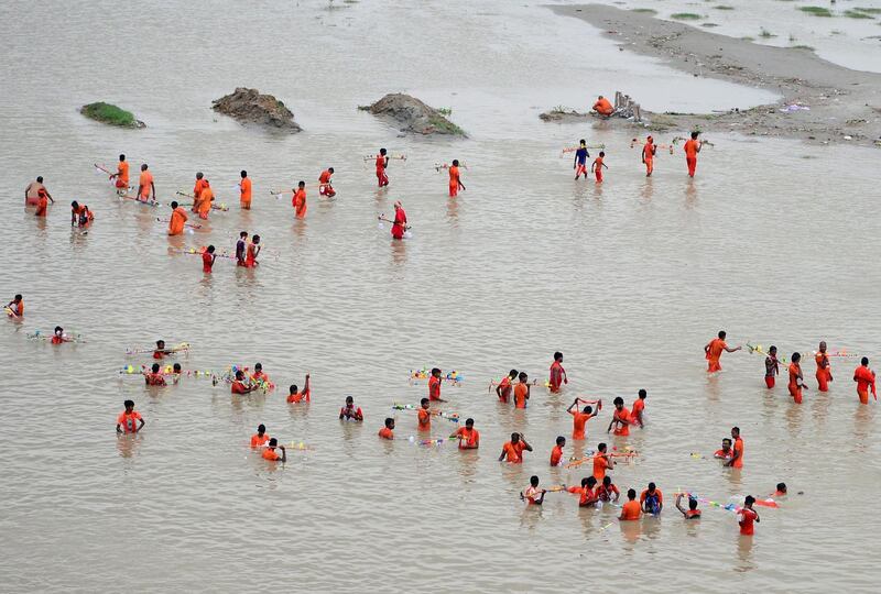 Indian kanwariya, devotees of the Hindu deity Shiva, collect water from the Ganges river for their ritualistic walk towards Varanasi during the holy month of Shravan, in Allahabad. Shravan is considered the holiest month in the Hindu calendar with many religious festivals and ceremonies.   AFP