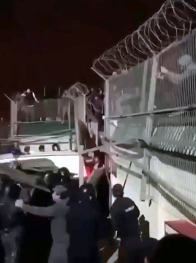 Police try to prevent a crowd from breaking into the airport