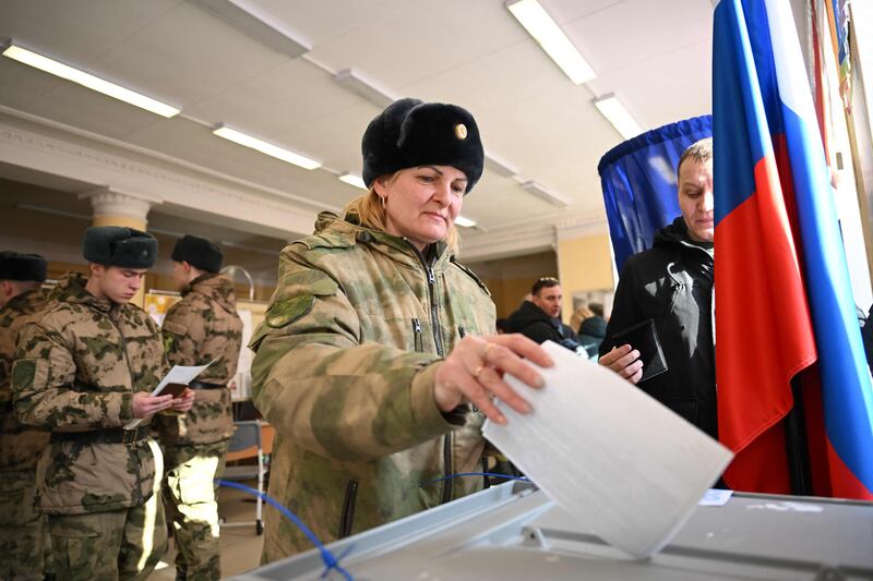 A member of the armed services votes in Russia's presidential election, in Moscow. AFP