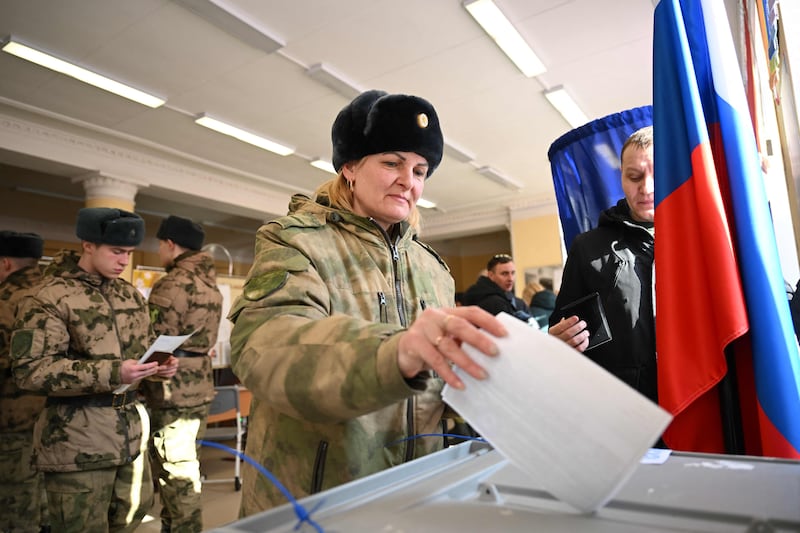 A service member casts her ballot in Russia's presidential election in Moscow on March 15, 2024.  (Photo by NATALIA KOLESNIKOVA  /  AFP)