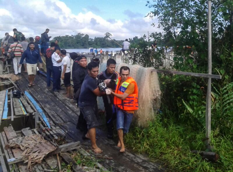 Rescuers take away survivors after a ferry carrying about 45 people capsized in Tanjung Selor, North Kalimantan, Indonesia. Nurindra Wijaya / AFP Photo