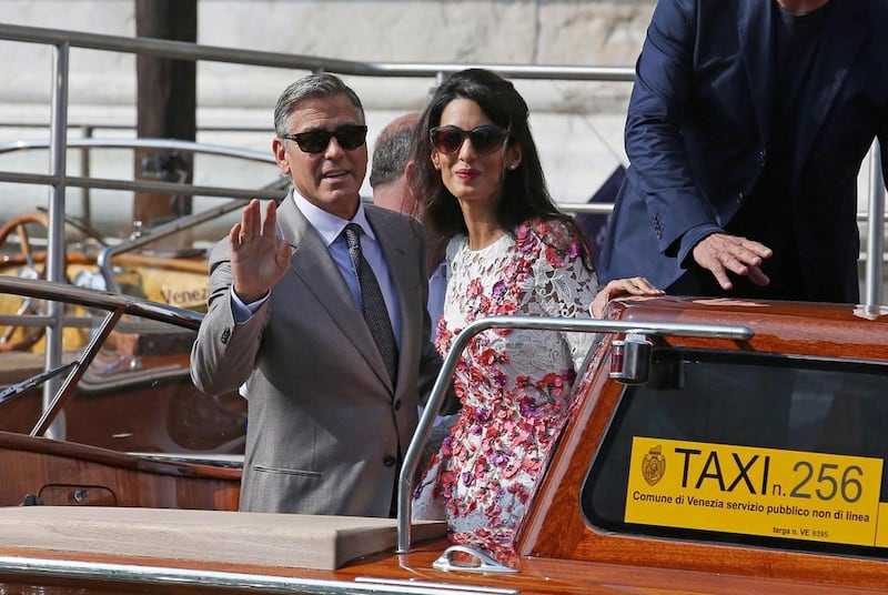 George Clooney and his wife Amal Alamuddin wave to photographers in Venice, Italy, during their wedding weekend in 2014. EPA