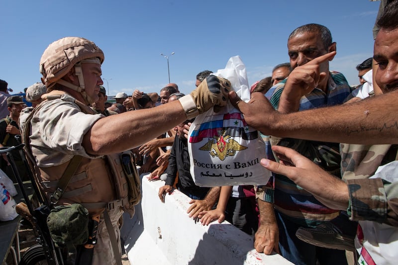 Russian soldiers distributing food in Syria. AP