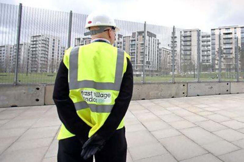 A security guard looking at the Olympic Village site, where the flats used by the athletes during the London Olympic Games are being turned into apartments for sale, rent and affordable housing at the Queen Elizabeth Olympic Park, London. Philip Toscano/ AP Photo