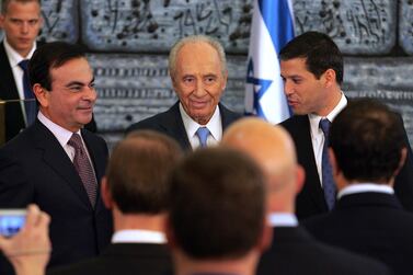Then Israeli President Shimon Peres (C) stands alongside President of French automaker Renault-Nissan Carlos Ghosn (L) during a 2008 joint press conference at the president's residence in Jerusalem. AFP