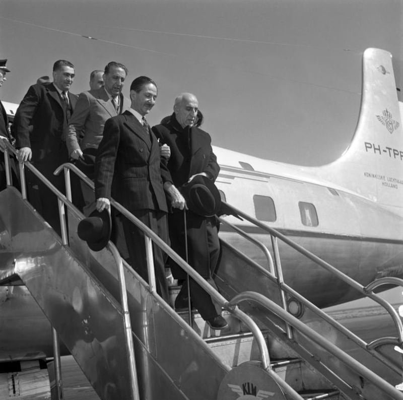 the former Iranian prime minister Mohammad Mosaddeq, right, escorted down the steps of a plane. In a coup supported by the British and US governments, Mosaddeq was removed from power on August 19, 1953. AFP / Getty




