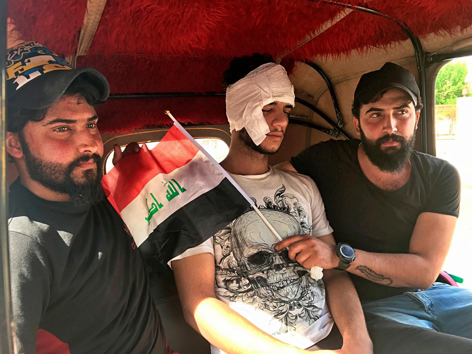 An injured protester leaves the hospital after being treated in Baghdad, Iraq, Friday, Oct. 25, 2019. Iraqi police fired live shots into the air as well as rubber bullets and dozens of tear gas canisters on Friday to disperse thousands of protesters on the streets of Baghdad, sending young demonstrators running for cover and enveloping a main bridge in the capital with thick white smoke.  (AP Photo/Ali Abdul Hassan)